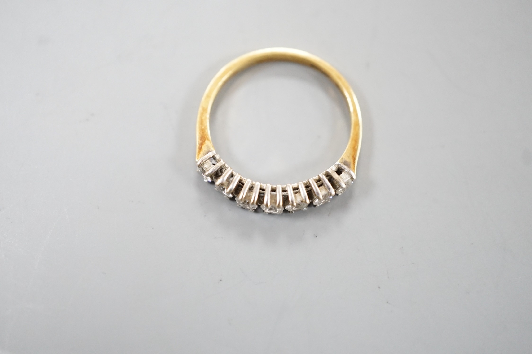 An 18ct gold and seven stone diamond set half hoop ring, size K, gross weight 1.8 grams.